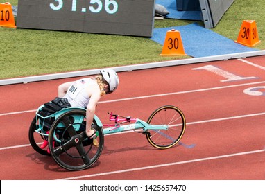 An isperational and determined high school wheelchair athlete is in lane three finishing her race on a red track. - Powered by Shutterstock