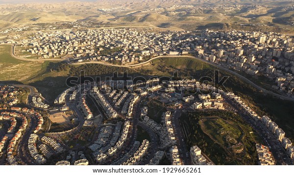 Israel and Palestine divided by security\
wall, aerial view\
drone view with anata refugees camp and pisgat\
zeev neighborhood\
