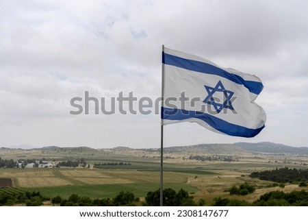 The Israeli flag against the background of the Golan Heights and Syria