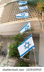 Israeli Flag With Star Of David Waving In The Wind On A Tight Rope In Front Of Windows Of A Residental Building