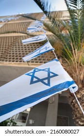 Israeli Flag With Star Of David Waving In The Wind On A Tight Rope In Front Of Windows Of A Residental Building
