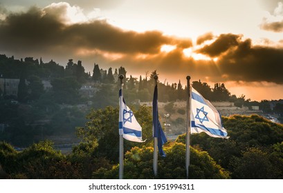 Israeli flags with dramatic stormy sunrise over Mount Zion, Jerusalem, which contains sites that are sacred to Judaism, Christianity and Islam