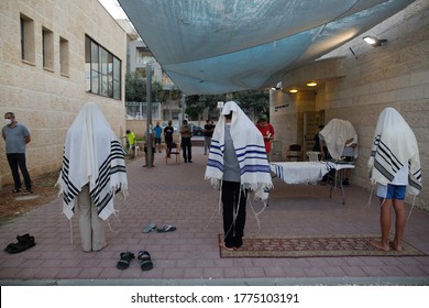 Israeli Jewish religious pray beside their synagogue  separated to insure social distancing spread of the novel coronavirus in Modiin Israel July 9,2020.