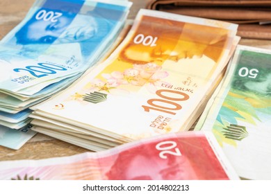 Israeli new shekels on wooden background. Save money concept.