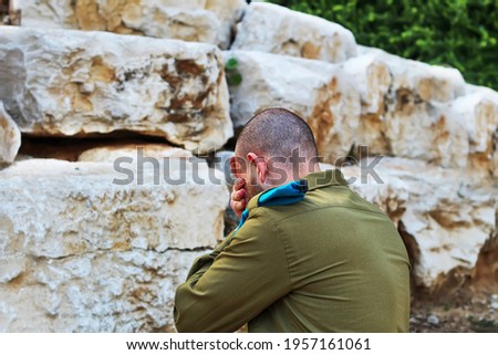 Israeli soldier crying and mourning for the fallen soldiers. Concept: Israeli soldiers, Israel Memorial Day - Yom HaZikaron