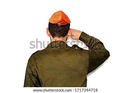 Israeli soldier (Israel Defense Forces, IDF) salutes on white isolated background.  Soldier in army Tzahal uniform with a orange beret on his head. Soldier Israeli Home Front Command