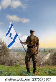 Israeli soldier with Israel flag against the sunset in the blooming desert. Concept - armed forces of Israel.
