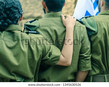 Israeli soldiers with flag of Israel on blurred background of Western Wall