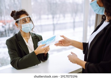 Issuance Of Protective Masks In The Office. The Administrator Issues Protective Sterile Masks For The Office Staff. Teamwork During Pandemic In Quarantine City. Covid-19.