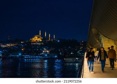 Istanbul Night. People On The Halic Metro Bridge And Suleymaniye Mosque On Background. Noise Included And Selective Focus On Foreground. Istanbul Turkey - 10.15.2021