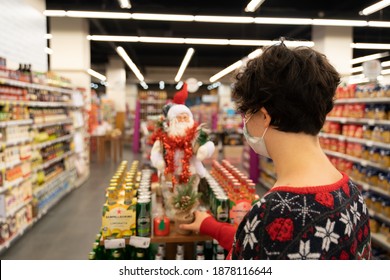 Istanbul, TR - December 16 2020: 
Shopping Woman Wearing Medical Mask Short Hair Ugly Christmas Sweater. Grocery Stores, Supermarkets Decorated Their Stands For New Year, Christmas. Santa Claus. 2021