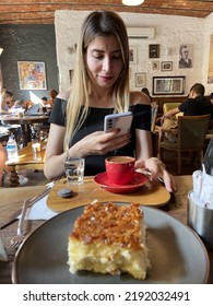 ISTANBUL - TURKEY - 13.08.2022
The Lady Is Sitting In The Cafe Taking Pictures Of German Cake And Turkish Coffee In Front Of Her Phone In Her Hand