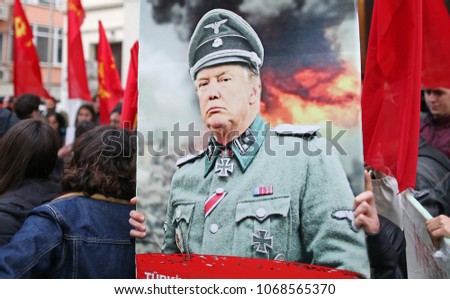 ISTANBUL, TURKEY, 14 APRIL 2018. A protestor hold picture of US President  Donald J. Trump with Nazi uniform during a protest against the United States.