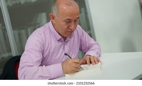 Istanbul, Turkey - 2019: Ahmet Şimşirgil is writing a historical book. Book fair signing day.                           