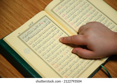 istanbul, turkey, 2022: reading quran and pointing to word of allah with finger. 