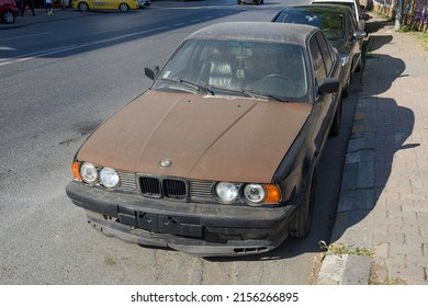 ISTANBUL, TURKEY - APRIL 30, 2022:  Slightly Rusty Destroyed BMW 5 Sedan Car. Black Metallic Color BMW 5-Series 525i E34, Luxury Old 90s Car.