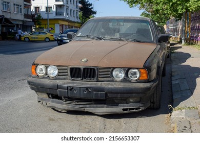 ISTANBUL, TURKEY - APRIL 30, 2022:  Slightly Rusty Destroyed BMW 5 Sedan Car. Black Metallic Color BMW 5-Series 525i E34, Luxury Old 90s Car.