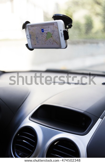ISTANBUL, TURKEY\
- AUGUST 26, 2016: Woman hands holding iPhone 6 with Apple Maps in\
the screen on the multimedia system. iPhone, Apple Maps was created\
and developed by the Apple\
inc.