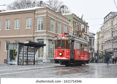 ISTANBUL TURKEY- FEBRUARY 24, 2019: Red Nostalgic Tram Is Moving On The Istiklal Street In Beyoglu, Taksim, In Winter Day With Snow. Cold Snowy Weather In Turkey. Flu Season.