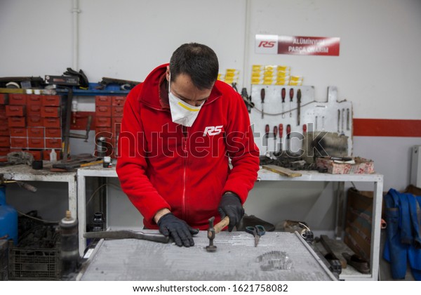 Istanbul, Turkey- January\
20, 2020. Labor is working in a car repair shop to fix on the car\
radiator parts.