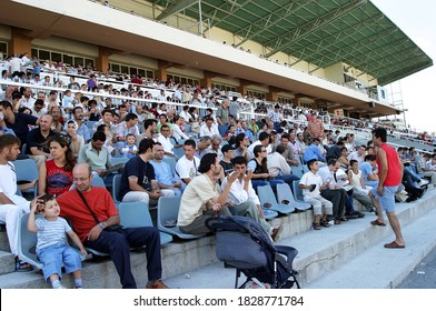 ISTANBUL, TURKEY - JULY 20: Turkish Horse Racing Fans Watching The Horse Race At The Tribune In Veliefendi Hippodrome On July 20, 2005 In Istanbul, Turkey.