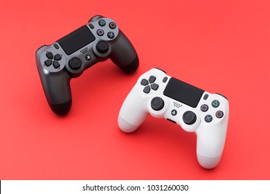 ISTANBUL, TURKEY - MAY 28, 2017: The new Sony Dualshock 4 white and gunmetall color is on the red background. Sony PlayStation 4 game console of the eighth generation.