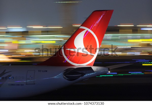 ISTANBUL, TURKEY - NOVEMBER 28, 2017; Turkish\
Airlines (TK) Airbus A330 passenger widebody jet aircraft tail with\
airline logo airport in night at Ataturk (IST) airport with light\
trails in background