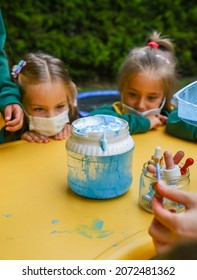 ISTANBUL, TURKEY - October 01, 2021: Two Preschool Children With Facial Masks Watching Closely A Science Project In Which Blue Dye Dissolves In Water.