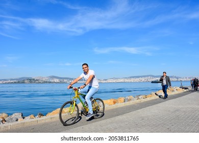 Istanbul, Turkey - October 17, 2017: Handsome young Arab man riding bicycle beside Bosphorus in Istanbul city.