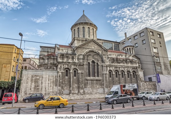 ISTANBUL, TURKEY - SEPTEMBER 28, 2013: The old\
Church of St Peter and St Paul surrounded by newer buildings, tram\
wire and road.