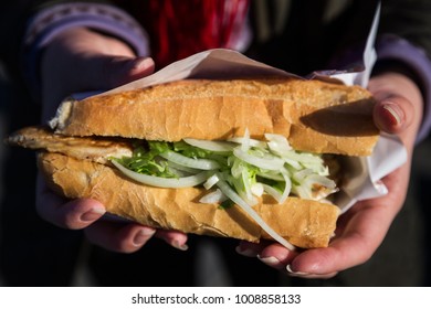 Istanbul, Turkey - Traditional Grilled Fish Sandwich With Onion Which Is Sold Near Galata Bridge At Eminonu District In Girl’s Hands.