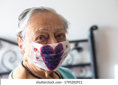 Istanbul / Turkey-July 19, 2020: Portrait Of Old Woman In A Medical Mask With Purple Heart Pattern. Dangers Of Coronavirus For Elderly, Handmade Protective Masks, Pandemic, Covid-19, Stay Home, Health