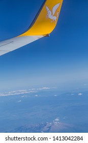 Istanbul, Turkey-may 04, 2019: International Airport Sabiha Gökçen International Airport, The Wing Of A Passenger Airliner Pegasus With A Yellow Logo Of A Horse In Flight In The Blue Sky