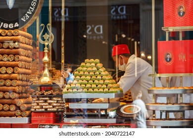ISTANBUL, View of a dessert shop display from exterior, customers buying Baklava, Rolled Kadayif, Pistachio Halep traditional Turkish desserts on showcase Istiklal Street Beyoglu Sept 6, 2021 Turkey
