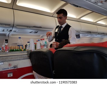 Istanbul,Turkey-28 September 2018: Male Cabin Crew Of Turkish Airlines Prepares Beverage On Flight Catering Trolley To Serve Passanger. 