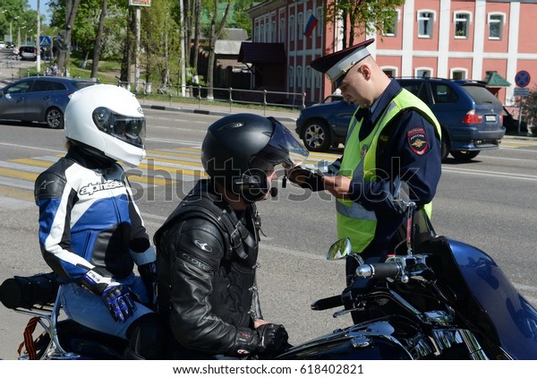 ISTRA, RUSSIA - MAY\
14,2016:The inspector of traffic police checks the documents of the\
motorcycle.