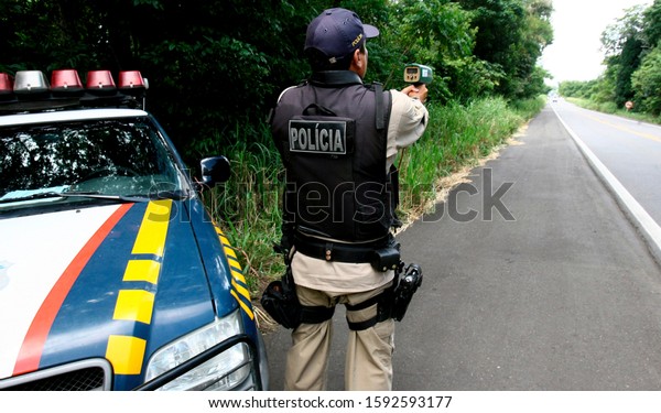 ITABUNA, BAHIA / BRAZIL -\
February 28, 2012: Federal Highway Police Officer - PRF - is seen\
using a handheld radar device to control vehicle speed on the BR\
101 Highway. 