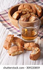 Italian almond biscotti biscuits and sweet wine in a glass on the table. vertical