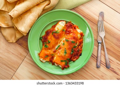 Italian American Baked Pasta Dish Stuffed Manicotti On Wooden Kitchen Table