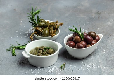 Italian appetizer. Mediterranean snack assortment olives, capers with fresh rosemary in a small bowl on a gray background. place for text, top view. - Powered by Shutterstock