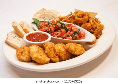 Italian Appetizer Sampler Platter Featuring Bruschetta With Sliced Baguette, Deep Fried Calamari And Breaded Mozzarella Cheese Rounds With A Ramekin Of Marinara Sauce