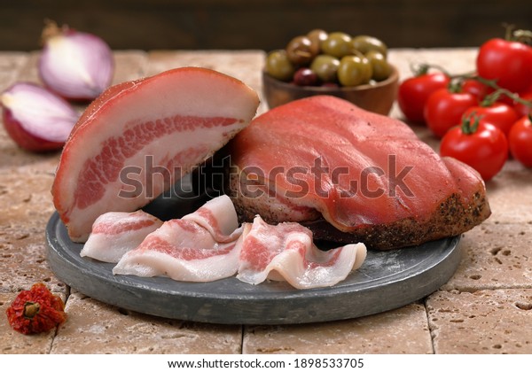 Italian bacon\
salted pork cheek on chopping\
board
