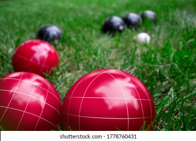 Italian Bocce Ball, Bocci Or Boccie Red And Blue White Balls On Green Lawn Close Up. An Ancient Games Played In The Roman Empire 