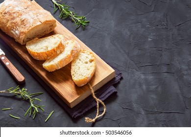  Italian bread Ciabatta and rosemary on black background - fresh homemade bread bakery - Powered by Shutterstock