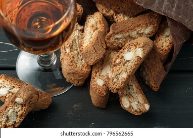Italian cantucci biscuits and a glass of sweet Vin Santo wine over wooden background