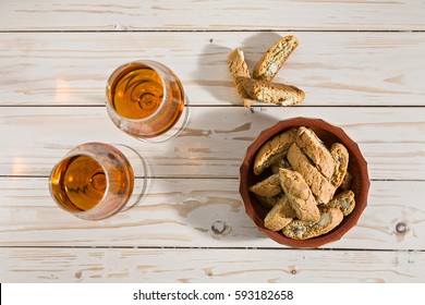 Italian cantucci biscuits and two glasses of vin santo wine on a table seen from above