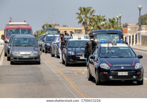 Italian Carabinieri with\
protective masks due to Coronavirus check people\'s\
self-certifications on the street during a checkpoint in Taranto,\
Puglia, Italy -\
11/04/2020