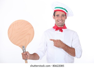 Italian Chef Pointing At A Wooden Pizza Peel