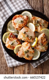 Italian Chicken Piccata With Sauce, Lemon And Capers Close-up On A Plate. Vertical View From Above
