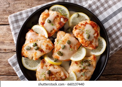 Italian Chicken Piccata With Sauce, Lemon And Capers Close-up On A Plate. Horizontal View From Above
